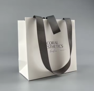 luxury matte white paper gift bag with silver foil logo and gray ribbon bow closure